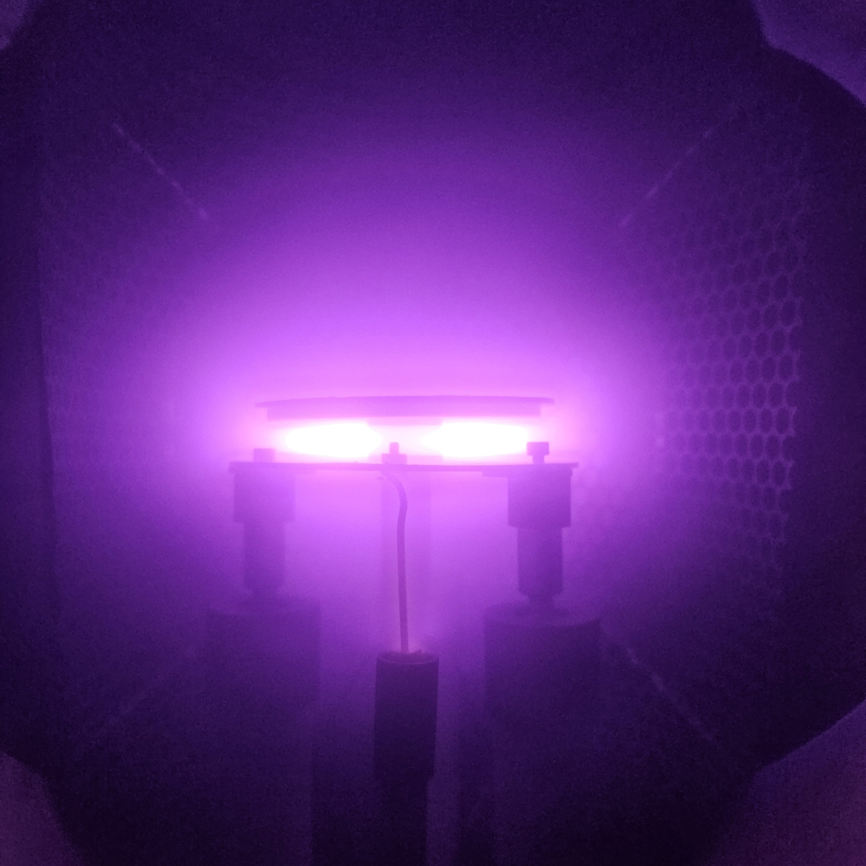 A bright purple glow inside the chamber of Patrick’s current experiment